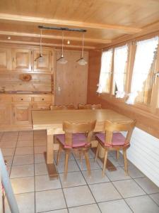 a kitchen with a wooden table and two chairs at Ferienwohnung Haus Bord in Sankt Antönien