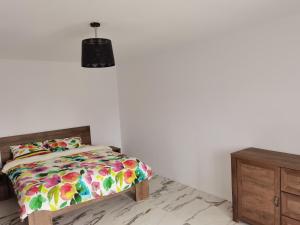 a bedroom with a bed and a dresser and a lamp at Apartament Garofitei in Constanţa