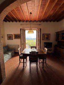uma sala de jantar com uma mesa e cadeiras e uma janela em Casa Femi em San Gimignano