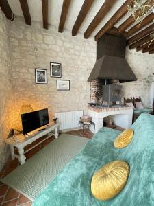 a bedroom with a bed and a stove at Le Relais, La Dormance, Le Bois Dormant in Châteauvieux