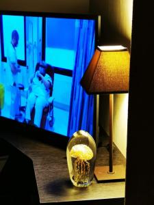 Cette chambre comprend une lampe, une télévision et un bol de pop-corn. dans l'établissement escale océane, à Wenduine