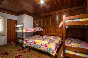 1 dormitorio con 2 literas y pared de madera en Pousada Cristo Redentor en Campos do Jordão