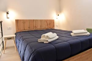 ein Schlafzimmer mit einem blauen Bett und Handtüchern darauf in der Unterkunft La Corte di Vincenzo in Noto