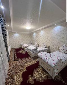Habitación con 3 camas y alfombra. en Nippon Hotel, en Samarkand