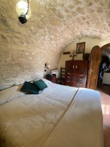 una camera con letto e parete in pietra di la casa di Sophie a Pettorano sul Gizio