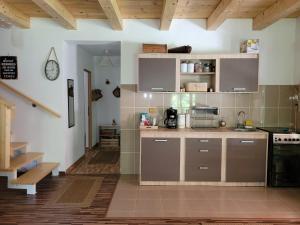 a kitchen with white walls and wooden ceilings at Cabana Praid in Praid
