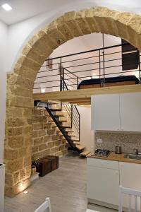 eine Küche mit Ziegelwand und Wendeltreppe in der Unterkunft La Corte di Vincenzo in Noto