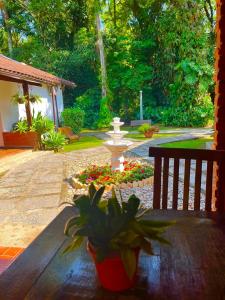 a wooden table with a fountain in a garden at Hotel Bertell in Penedo