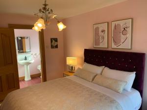 a bedroom with a large bed and a bathroom at Mayrone House B&B in Donegal