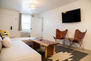 a living room with a couch and a table and chairs at High Creek Lodge and Cabins in Pagosa Springs