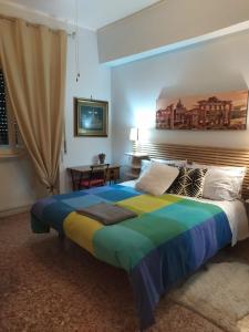 - une chambre avec un grand lit et un couvre-lit coloré dans l'établissement roma capoccia b&b, à Rome