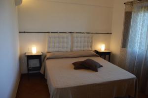 una camera da letto con un letto con due luci sopra di I DAMMUSI DEL VENTO a Pantelleria