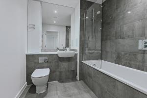 a bathroom with a toilet and a tub and a sink at Khayat Homes - The Owelor - Two Bed in London