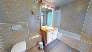 a bathroom with a toilet and a sink and a mirror at Le Sabot de Vénus in Val Thorens +29 photos