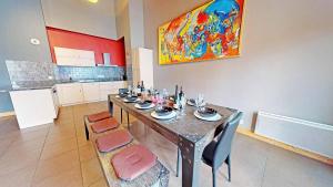 een eetkamer met een tafel en stoelen en een schilderij bij Le Sabot de Vénus in Val Thorens