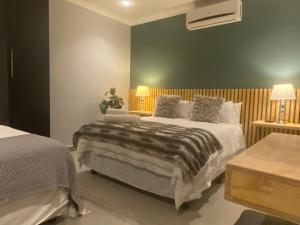 a bedroom with two beds and a green wall at La Benroy in Klerksdorp