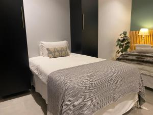 a bedroom with a bed with a black and white blanket at La Benroy in Klerksdorp