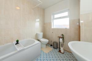 a bathroom with a tub and a toilet and a sink at Favourite by couple and group of 3 Cosy Apartment Close to City Centre in Reading