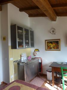 eine Küche mit einem Kühlschrank aus Edelstahl und einem Tisch in der Unterkunft Mini Appartement Colombana in Pallerone