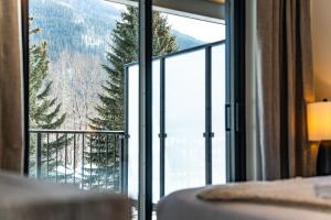 - une chambre avec une grande fenêtre offrant une vue sur la montagne dans l'établissement Peaks and Birdies by Revelstoke Vacations, à Revelstoke