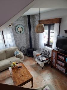 ein Wohnzimmer mit einem Sofa und einem Tisch in der Unterkunft Las Calendas de Atapuerca CB in Castrillo del Val