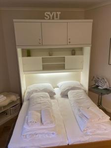 duże białe łóżko z 2 poduszkami w obiekcie Strandkoenig-Westerland-Terrasse-mit-Garten-Strandnaehe-PKW-Stellplatz w mieście Westerland