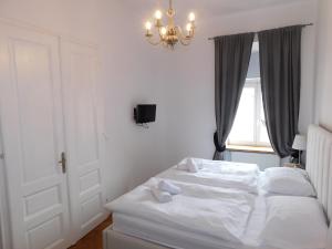een wit bed in een slaapkamer met een kroonluchter bij Cosy Resy place in Ljubljana