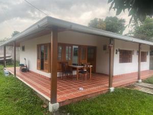 une petite maison avec une terrasse et une table dans l'établissement Casa de descanso acacias meta, à Acacías