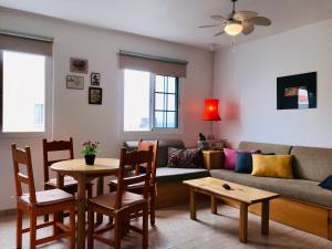salon z kanapą, stołem i krzesłami w obiekcie Casa Sunshine Cotillo Mar w mieście Cotillo