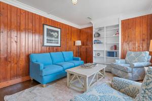 een woonkamer met een blauwe bank en een tafel bij Nags Head Beach Inn by KEES Vacations in Nags Head