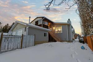 una casa en la nieve con una valla en Elegant Boho Retreat - 8 min to WEM, en Edmonton