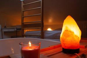 a candle and a fruit on a table next to a bed at La casa delle fate di fronte al mare in Livorno