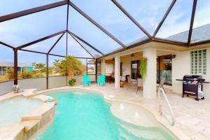 una piscina con patio y una casa en Magnolia Way Retreat en Punta Gorda