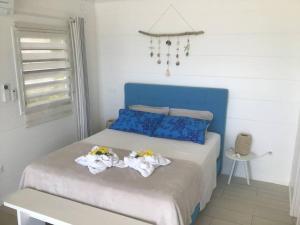 1 dormitorio con 1 cama con toallas en Pkbleucoco, en Opoa