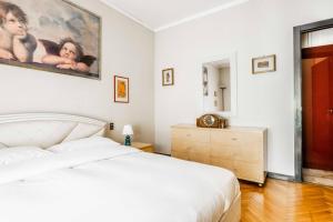 Un dormitorio con una cama blanca y una pintura en la pared en Morgantini House San Siro-Duomo "Netflix & Terrace", en Milán