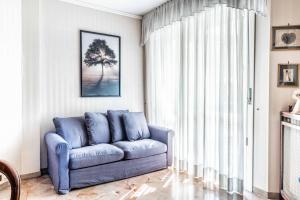 um sofá azul numa sala de estar com uma janela em Morgantini House San Siro-Duomo "Netflix & Terrace" em Milão