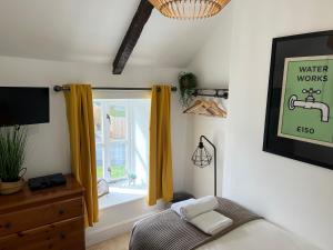 um quarto com uma cama e uma janela com cortinas amarelas em Spacious 4 Bedroom Farmhouse em Pembrokeshire
