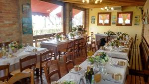 a dining room with white tables and chairs with flowers on them at Agriturismo La Barena in Jesolo