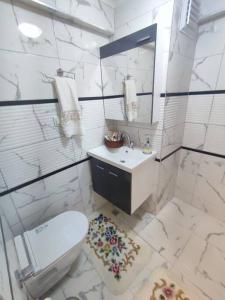 a white bathroom with a toilet and a sink at happymodernhouse konforlu evimiz in Marmaris
