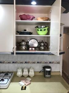eine Küche mit weißen Schränken mit Töpfen und Pfannen in der Unterkunft happymodernhouse konforlu evimiz in Marmaris