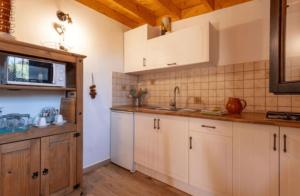 una cocina con armarios blancos y fregadero en Las Palmeras Temisas, en Temisas