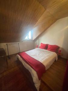 a bedroom with a large bed with red pillows at Entre Volcan et Montagnes in La Plaine des Cafres