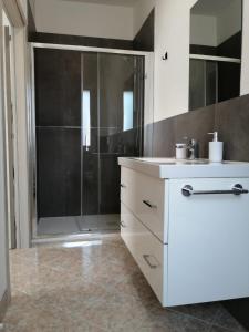 W łazience znajduje się prysznic i biała umywalka. w obiekcie MAWA w mieście Ferrara