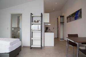 Habitación con cama, mesa y cocina. en Apartmenthaus Renz, en Aalen