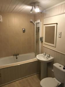 a bathroom with a sink and a toilet and a tub at The Priory Hotel in Louth