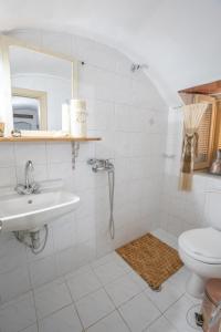 Un baño blanco con lavabo e inodoro. en Mansion House(est.c1890)-Daedalus, en Halki 46 fotos más