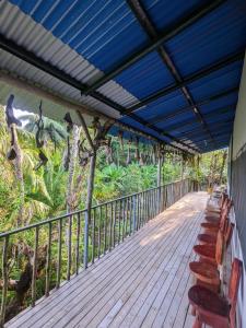 a deck with chairs and a blue roof at Ecobosque el mar in Rancho Quemado