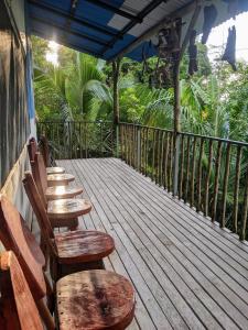 a row of chairs sitting on a wooden deck at Ecobosque el mar in Rancho Quemado