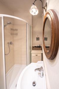 uma casa de banho com um lavatório, um chuveiro e um espelho. em Affittacamere Irene em Monterosso al Mare