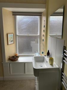 cocina con fregadero blanco y ventana en Dreel Cottage, en Anstruther